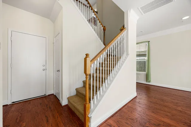 a view of a hallway with wooden floor and staircase