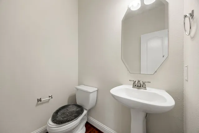 a bathroom with a sink a toilet and a mirror