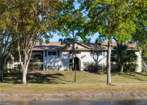 a front view of a house with a tree