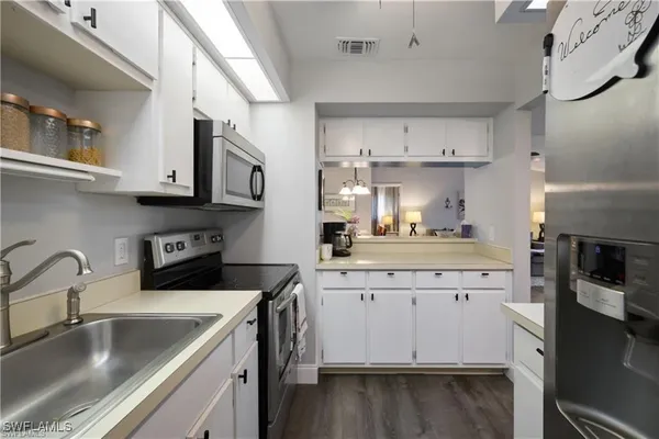 a kitchen with a sink a stove and cabinets