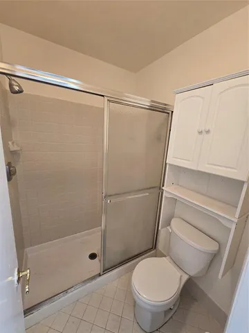 a white toilet sitting next to a shower