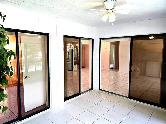 a view of a hallway with a chandelier fan and windows