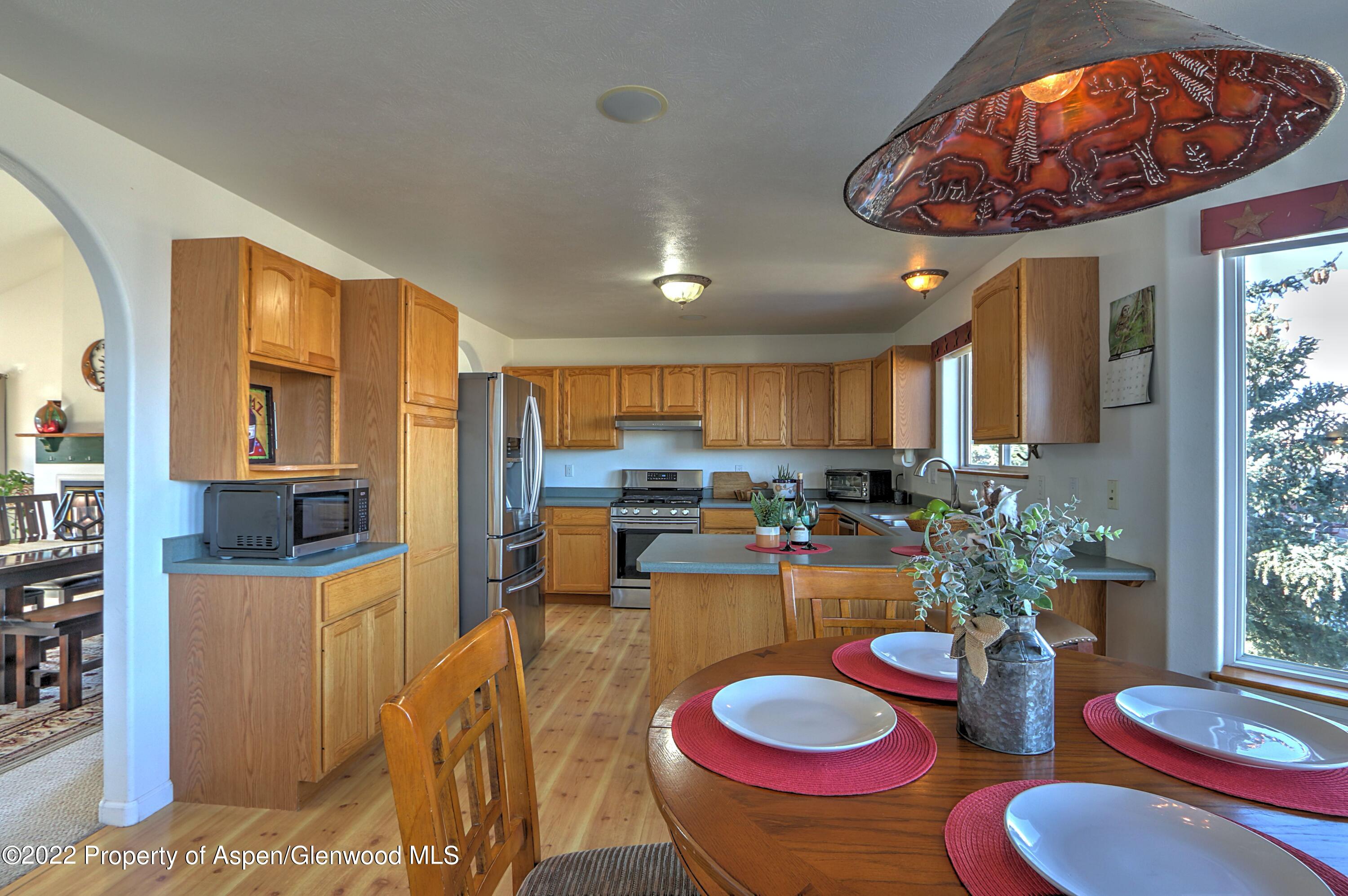 1220 Sage Court Rifle, CO 81650 - Photo 14 of 41 a view of a dining room with furniture a kitchen and chandelier