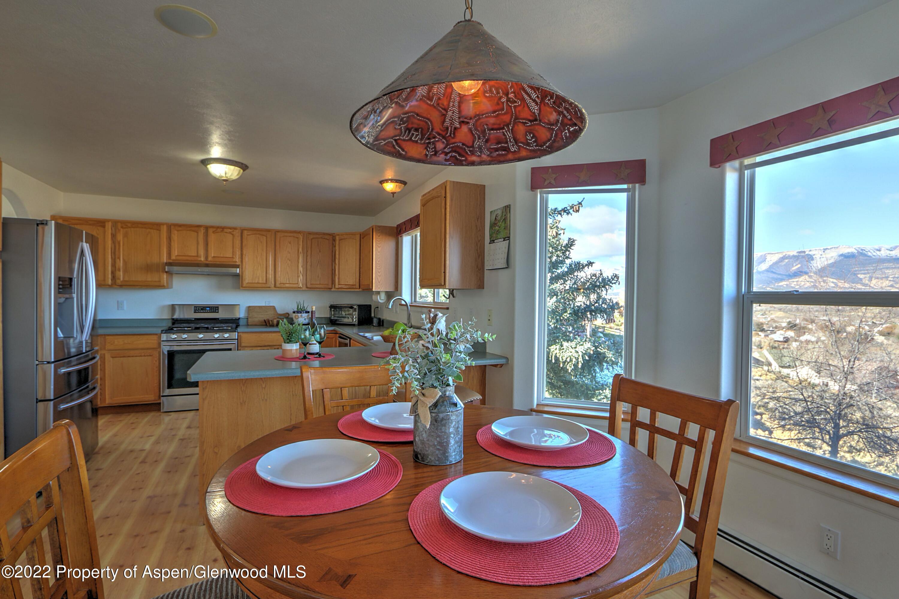 1220 Sage Court Rifle, CO 81650 - Photo 15 of 41 a kitchen with stainless steel appliances granite countertop a dining table and chairs