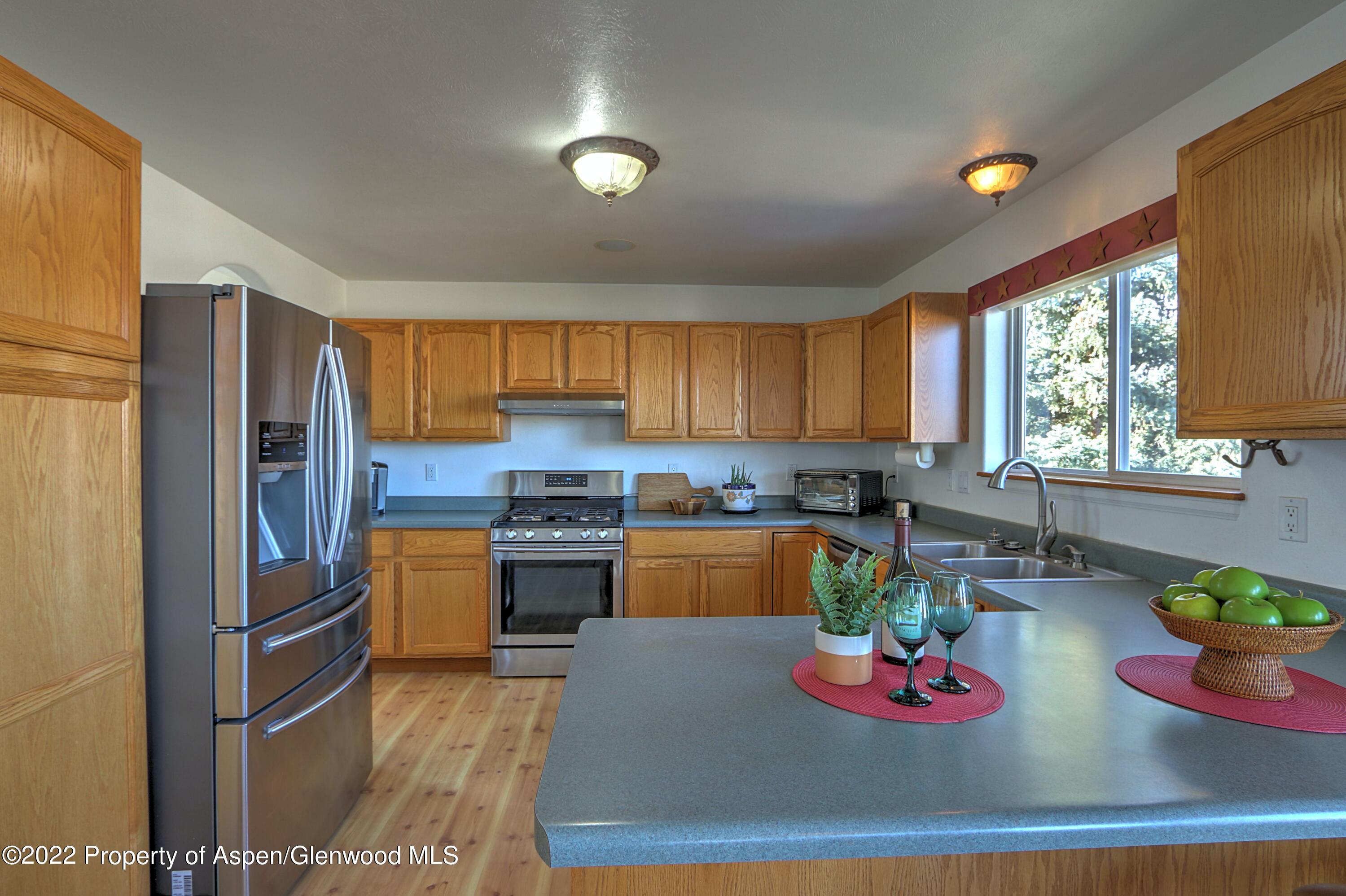 1220 Sage Court Rifle, CO 81650 - Photo 16 of 41 a kitchen with stainless steel appliances granite countertop a refrigerator sink and stove