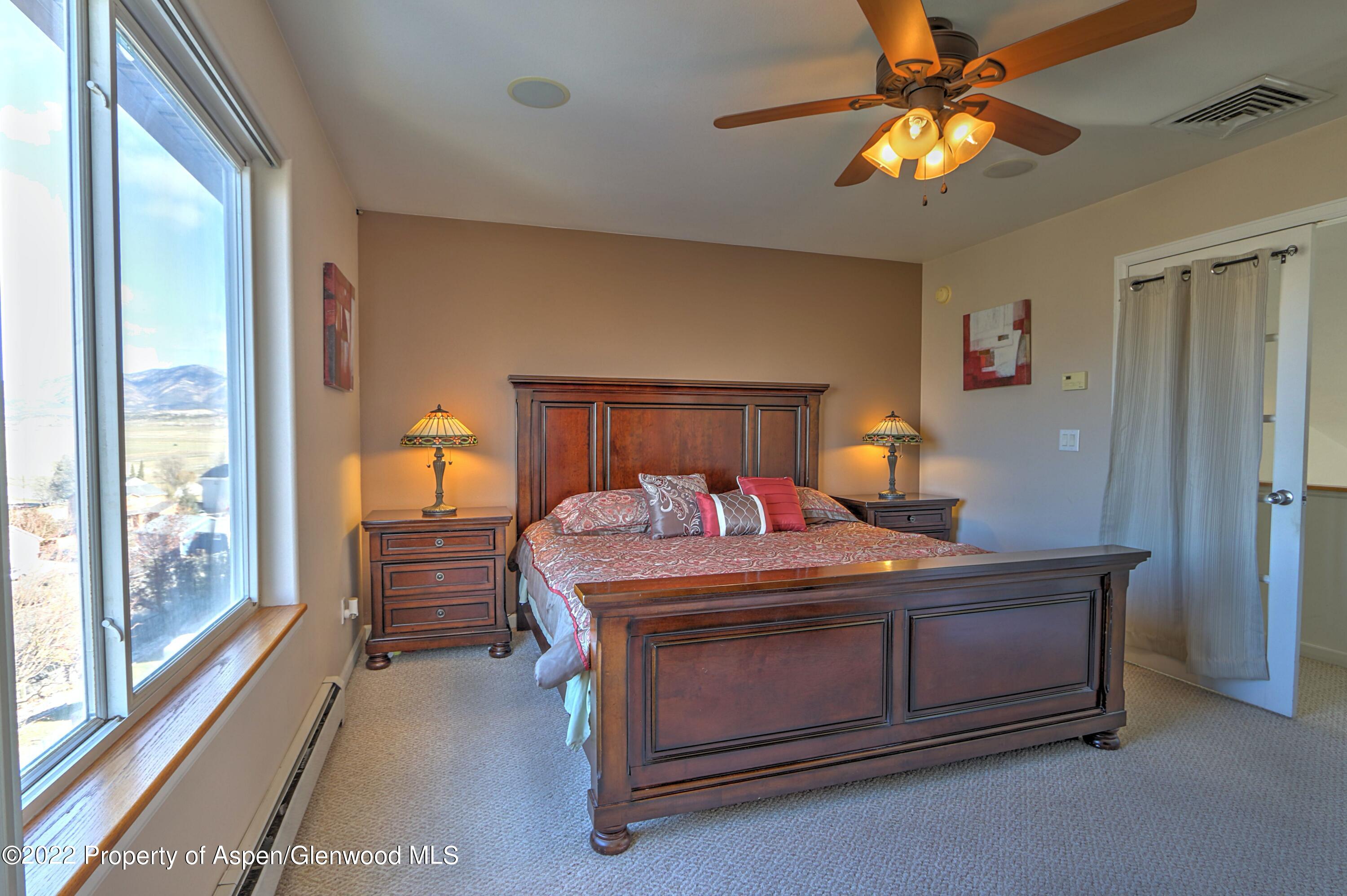 1220 Sage Court Rifle, CO 81650 - Photo 23 of 41 a bedroom with a bed and a chandelier