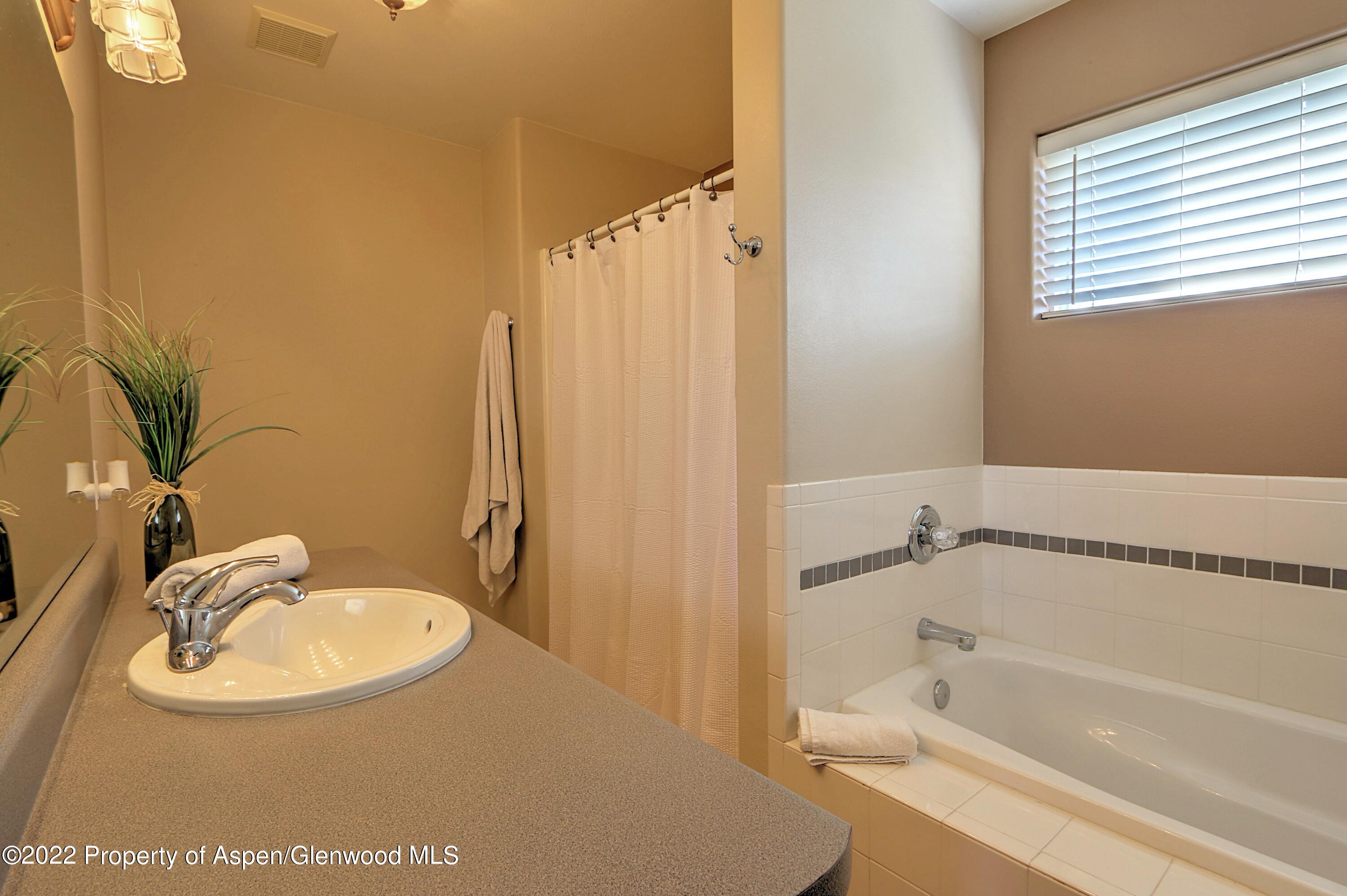 1220 Sage Court Rifle, CO 81650 - Photo 24 of 41 a bathroom with a sink a mirror and a bathtub
