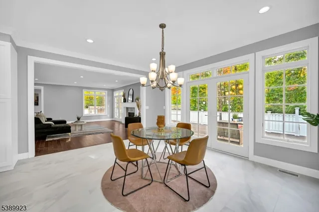a dining room with furniture a chandelier and wooden floor