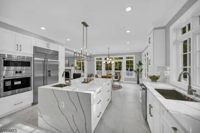 a large white kitchen with a large window and stainless steel appliances