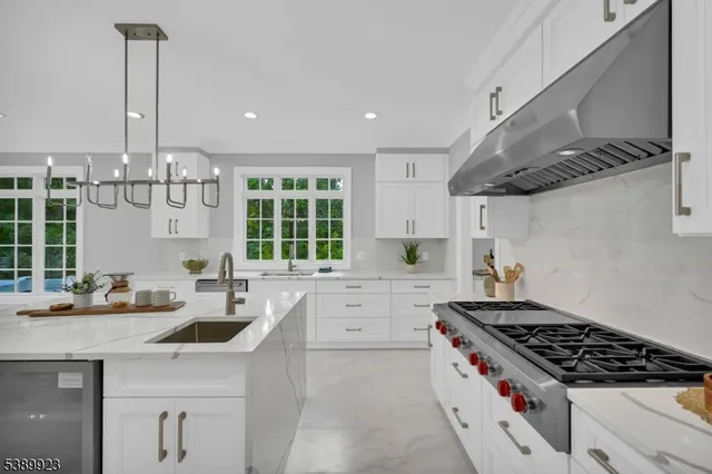 a kitchen with stainless steel appliances a sink a stove and a wooden floors