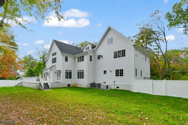 a front view of a house with a yard and tree