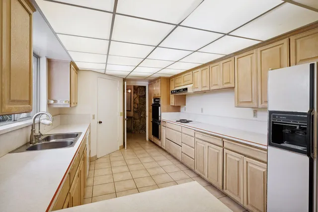 a kitchen with stainless steel appliances a sink cabinets and wooden floor