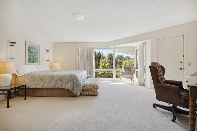 a bedroom with a bed and a large window