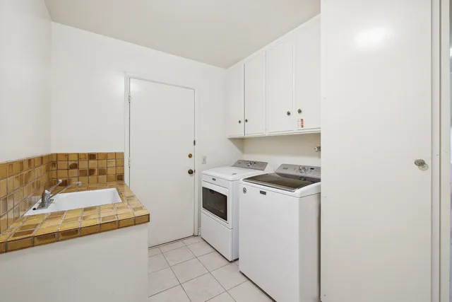 a kitchen with white cabinets and white appliances