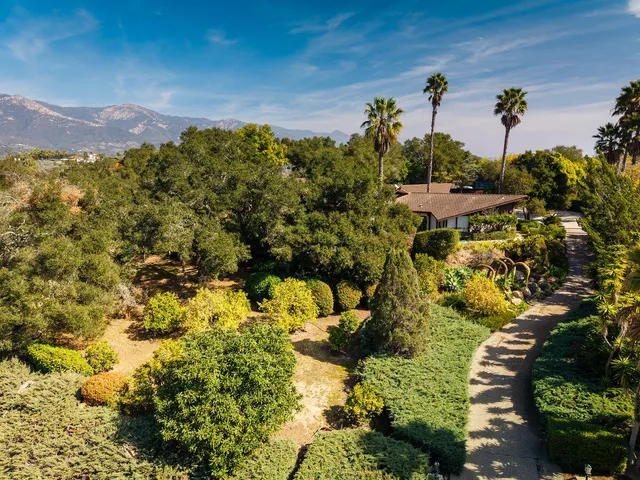 a view of swimming pool with lawn chairs under an umbrella