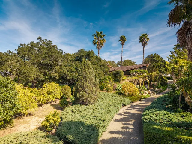 an aerial view of a house with a yard and trees