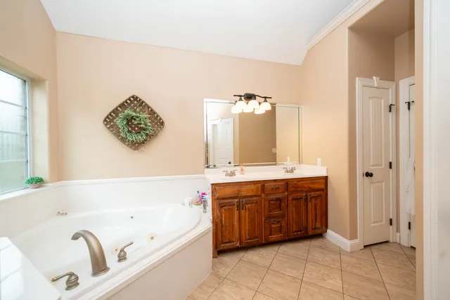 a bathroom with a tub sink and mirror