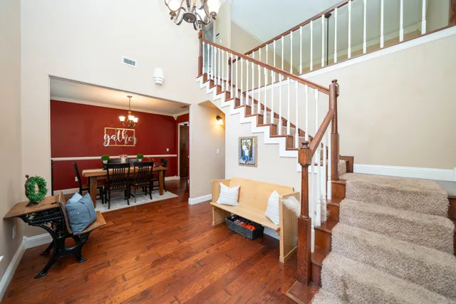 a living room with couches and a dining table with wooden floor