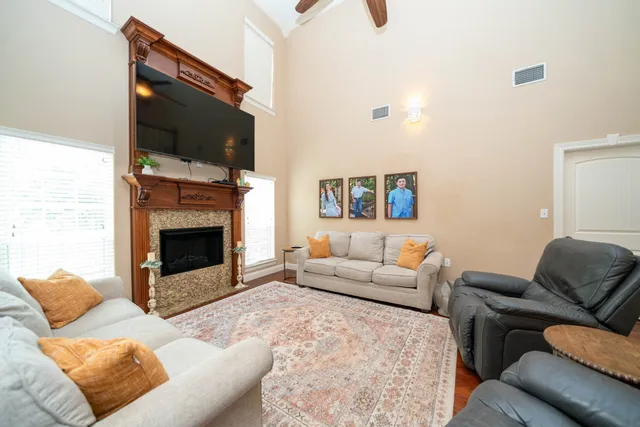 a living room with furniture a flat screen tv and a fireplace