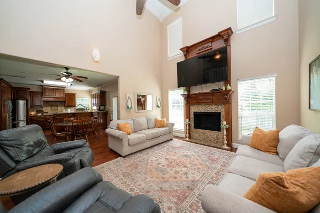 a living room with furniture a fireplace and a flat screen tv