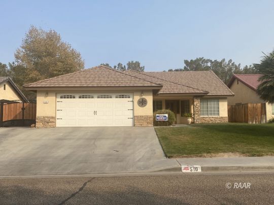 516 Amanda Street Ridgecrest, CA 93555 - Photo 1 of 9 a front view of a house with a garden and yard