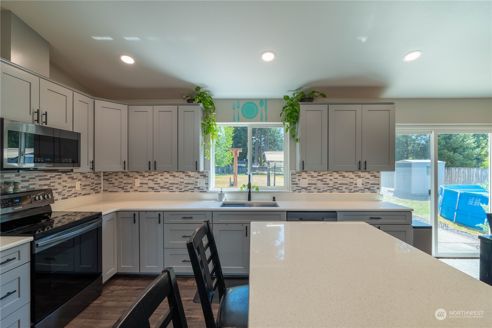 18940 Melon Street Southwest Rochester, WA 98579 - Photo 11 of 39 a kitchen with kitchen island granite countertop a stove and a sink