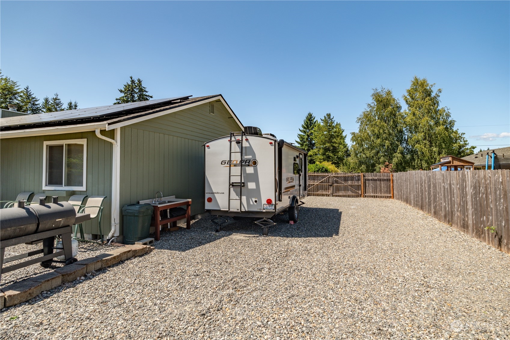 18940 Melon Street Southwest Rochester, WA 98579 - Photo 29 of 39 a roof deck with a table and chairs and wooden fence