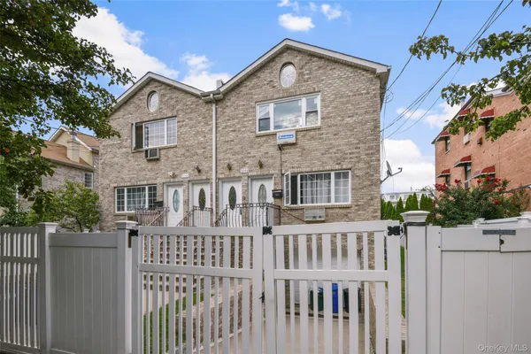 a view of a brick house with wooden fence