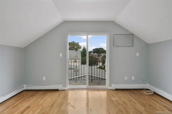 a view of a room with wooden floor and a window