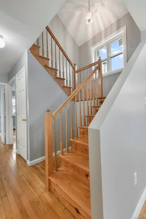 a view of staircase with wooden floor and white walls