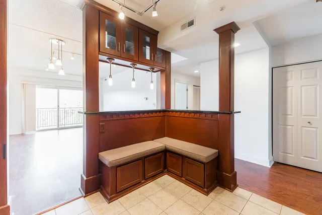a hallway with a large mirror on dresser and a wooden floor