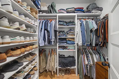 a view of walk in closet with clothes and shoes