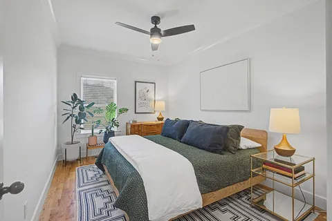 a bedroom with a bed and wooden floor