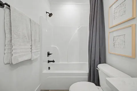 a bathroom with a toilet and a shower
