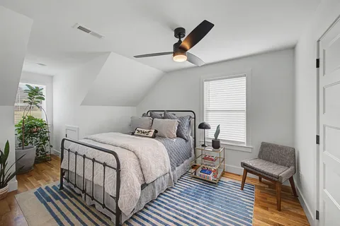 a bedroom with a bed and wooden floor
