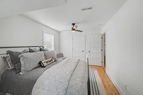 a spacious bedroom with a bed and a chandelier