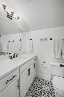 a bathroom with a sink a toilet and mirror