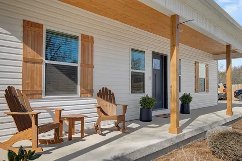 a view of a house with backyard and sitting area