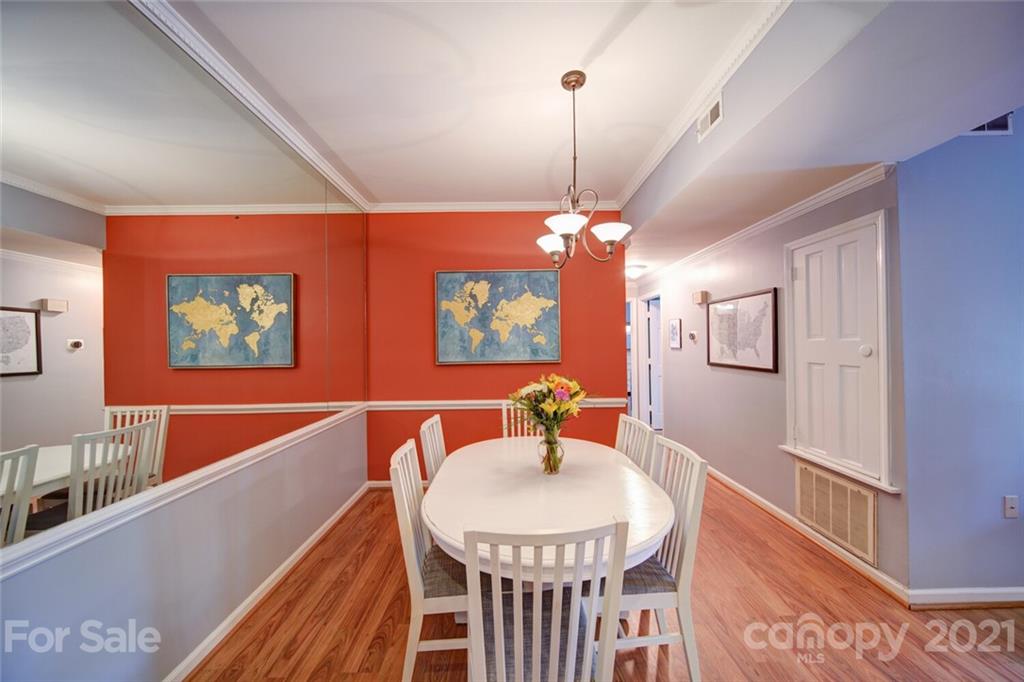 1014 Queens Road Charlotte, NC 28207 - Photo 16 of 18 a dining room with furniture a chandelier and wooden floor