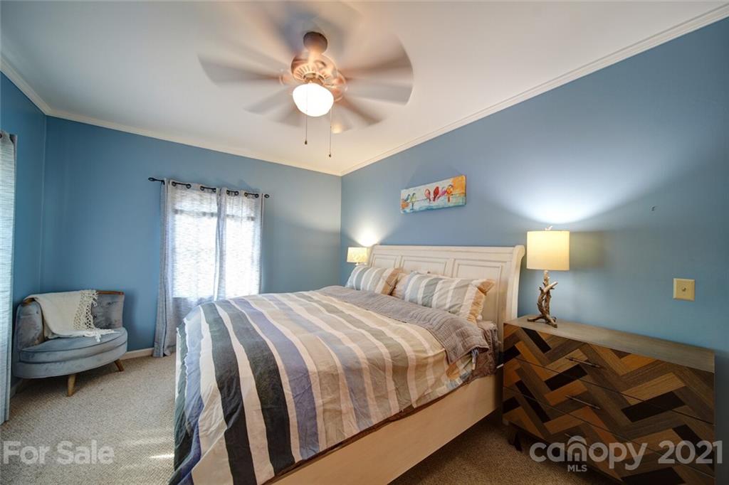 1014 Queens Road Charlotte, NC 28207 - Photo 3 of 18 a bedroom with a bed and a chandelier