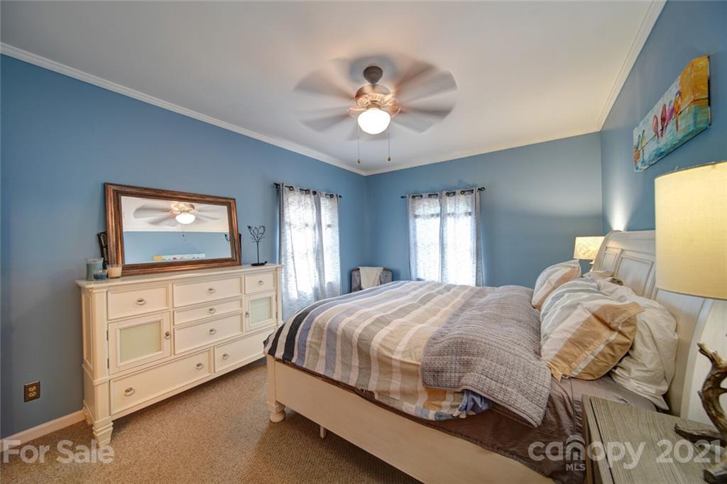 1014 Queens Road Charlotte, NC 28207 - Photo 5 of 18 a bedroom with a bed a chandelier and a flat tv screen on dresser