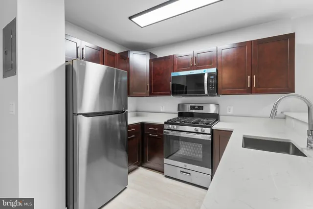 a kitchen with stainless steel appliances granite countertop a refrigerator stove and microwave