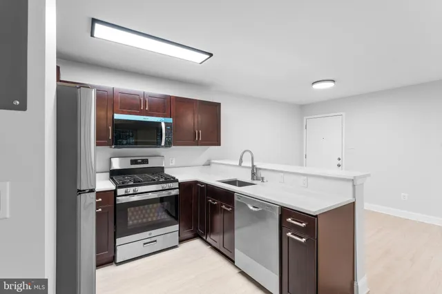 a kitchen with a sink a stove and microwave