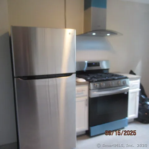 a kitchen with stainless steel appliances granite countertop a refrigerator and a stove