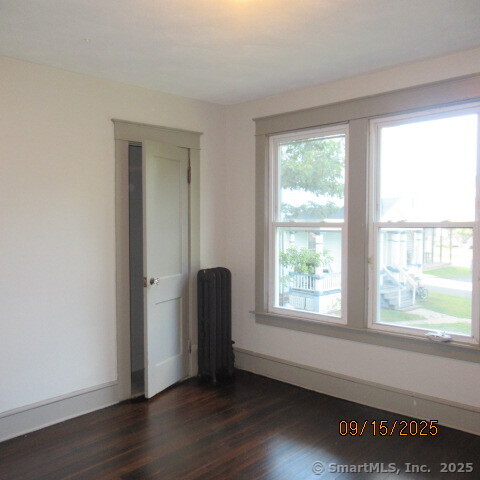 67 Burlington Avenue, Unit 69 Bristol, CT 06010 - Photo 8 of 15 a view of an empty room with wooden floor and a window