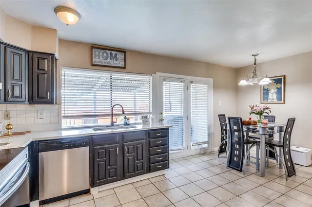 a kitchen with stainless steel appliances granite countertop a sink and a refrigerator