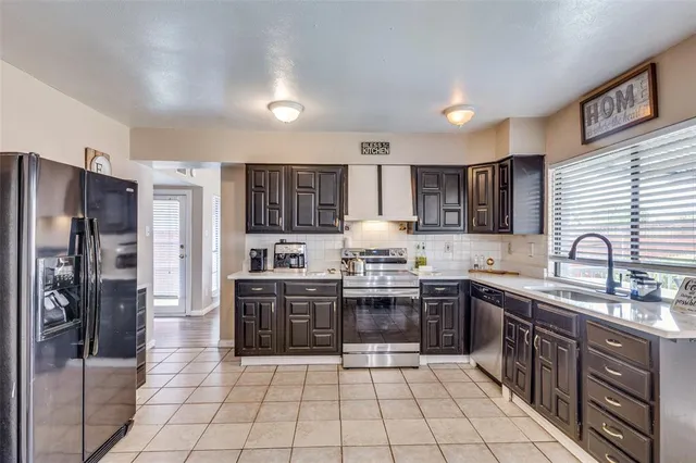 a kitchen with stainless steel appliances granite countertop a stove a sink dishwasher a refrigerator and cabinets