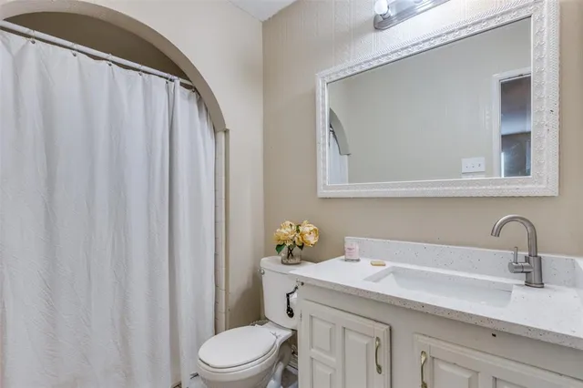 a bathroom with a sink a toilet and a mirror