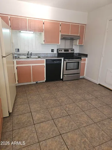 a kitchen with stainless steel appliances a sink a stove a microwave and a counter