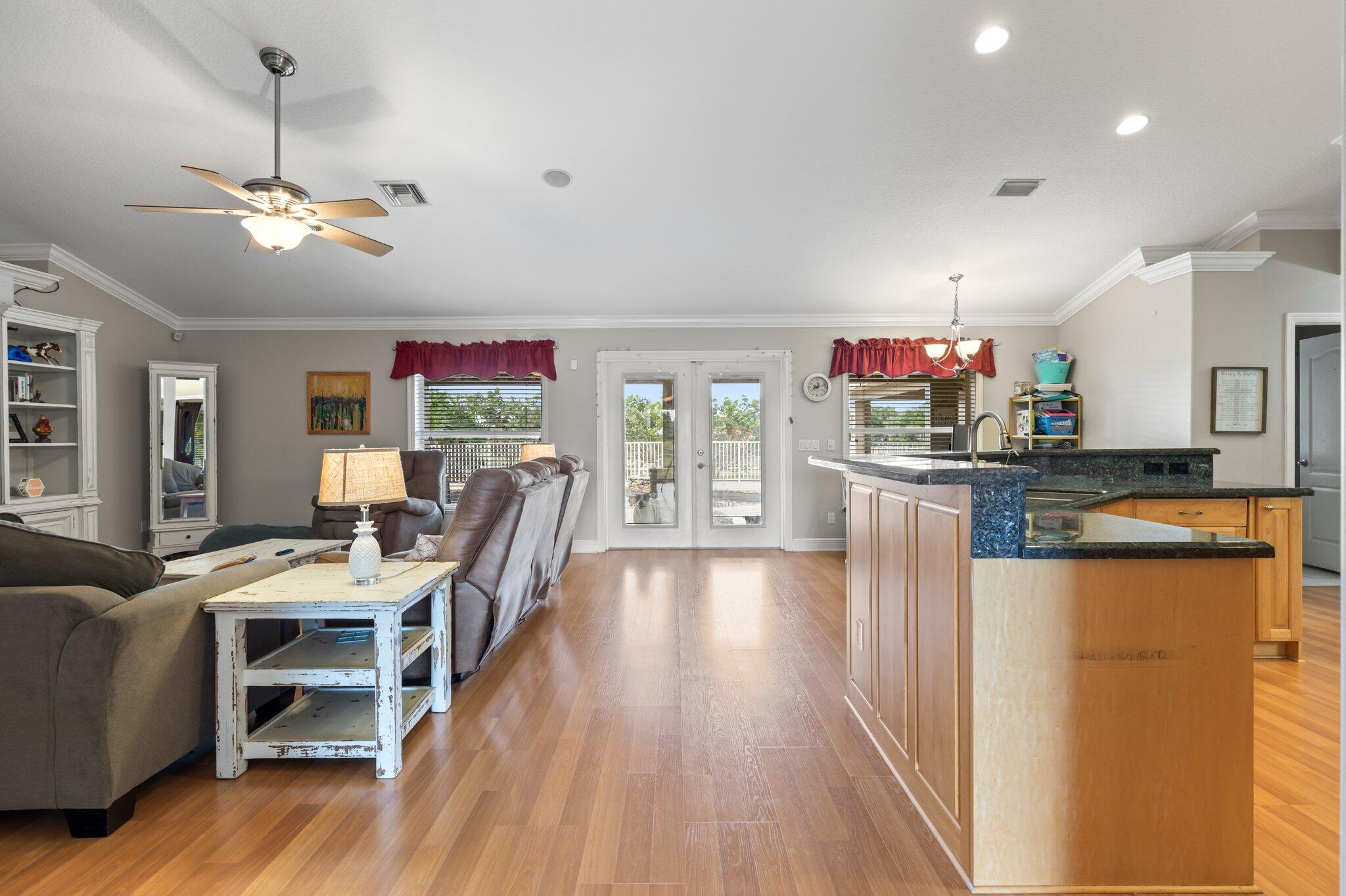 9850 Muller Road Fort Pierce, FL 34945 - Photo 9 of 52 a view of a dining room with furniture a chandelier and wooden floor